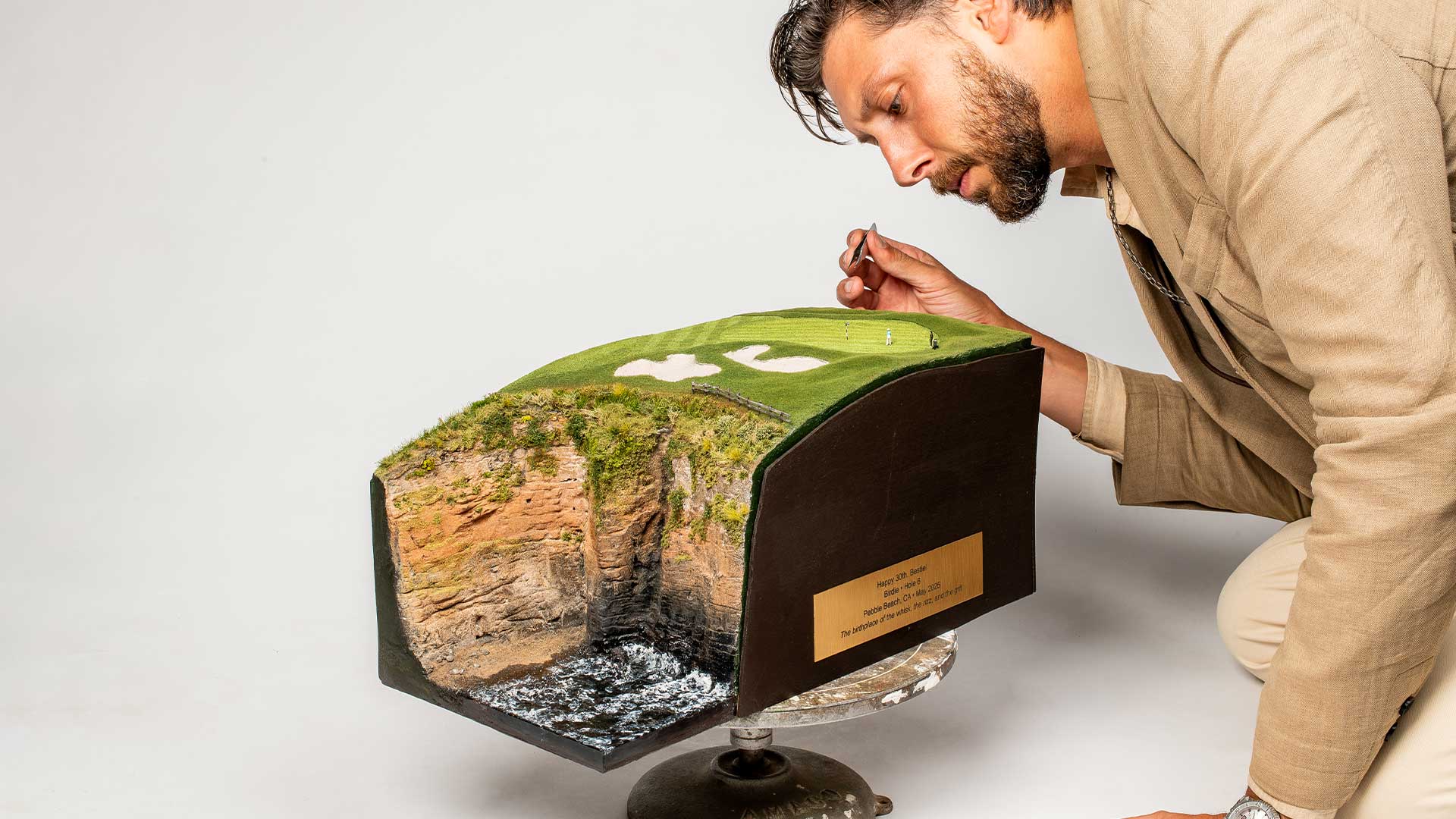 Micro landscape artist working on Pebble Beach Hole 6 replica for scale reference