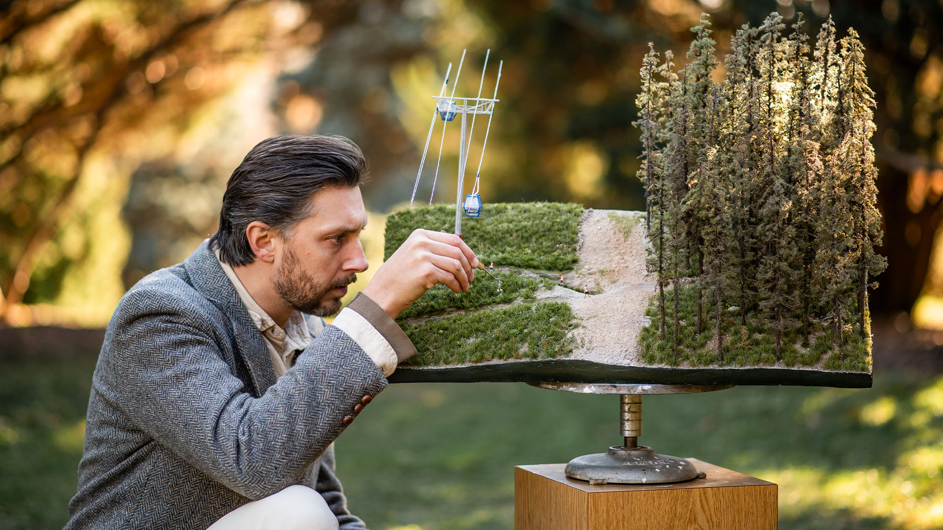 Artist working on the handcrafted Snow King Mountain micro landscape on pedistal for 29029 Everesting