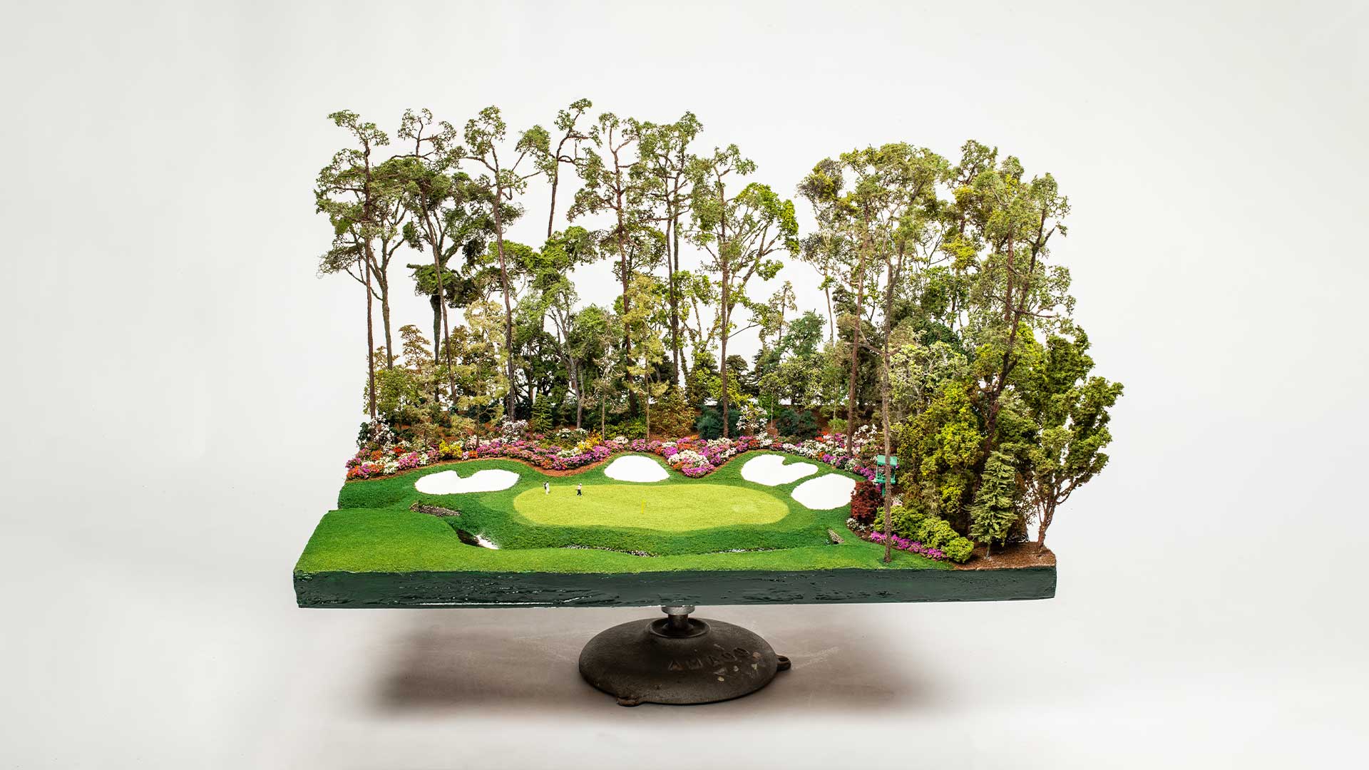 Handcrafted micro landscape of a famous par five golf green inspired by Southern Georgia, displayed on a pedestal