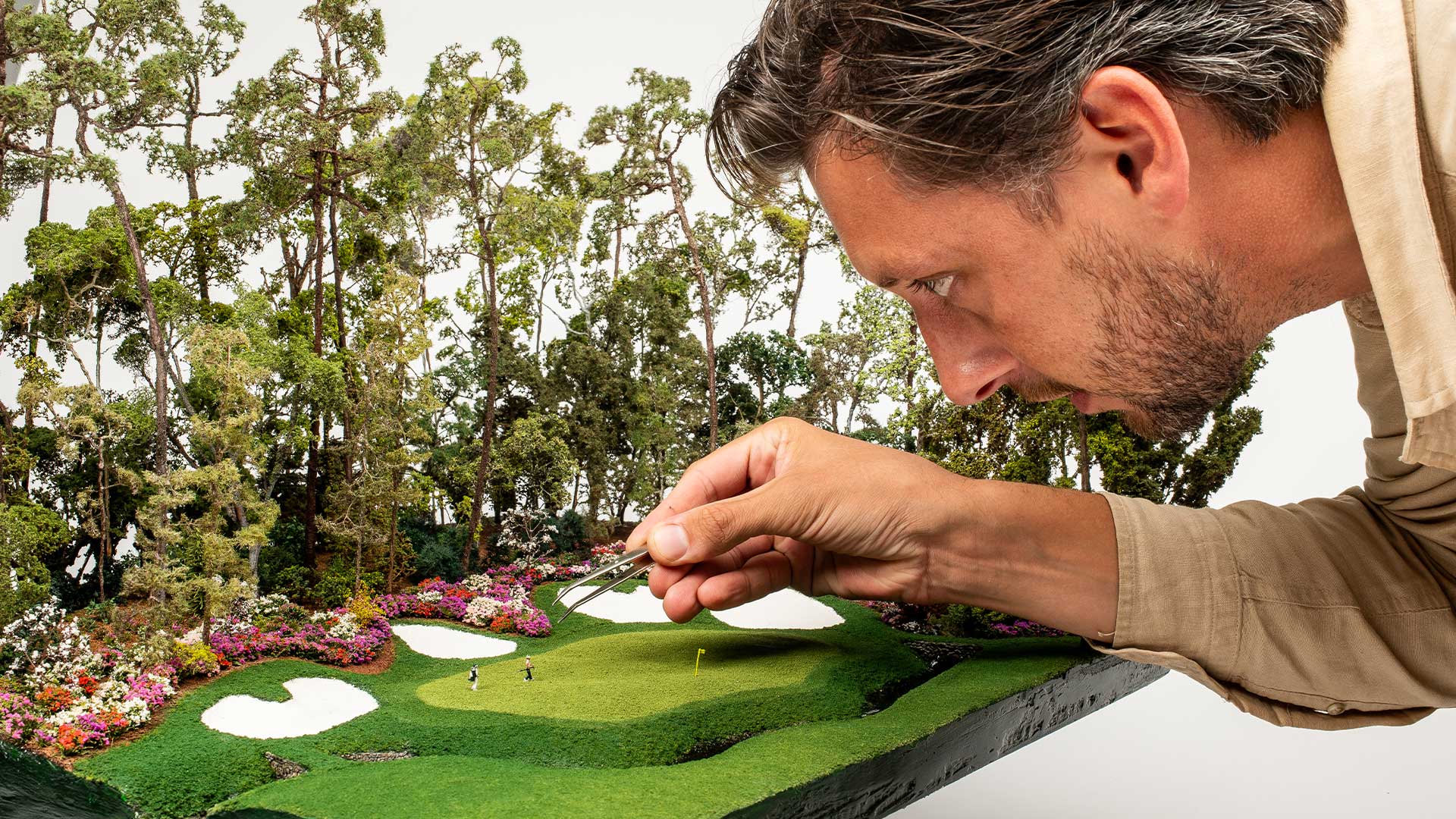 Micro landscape artist hand detailing a famous par five golf green for realism and accuracy