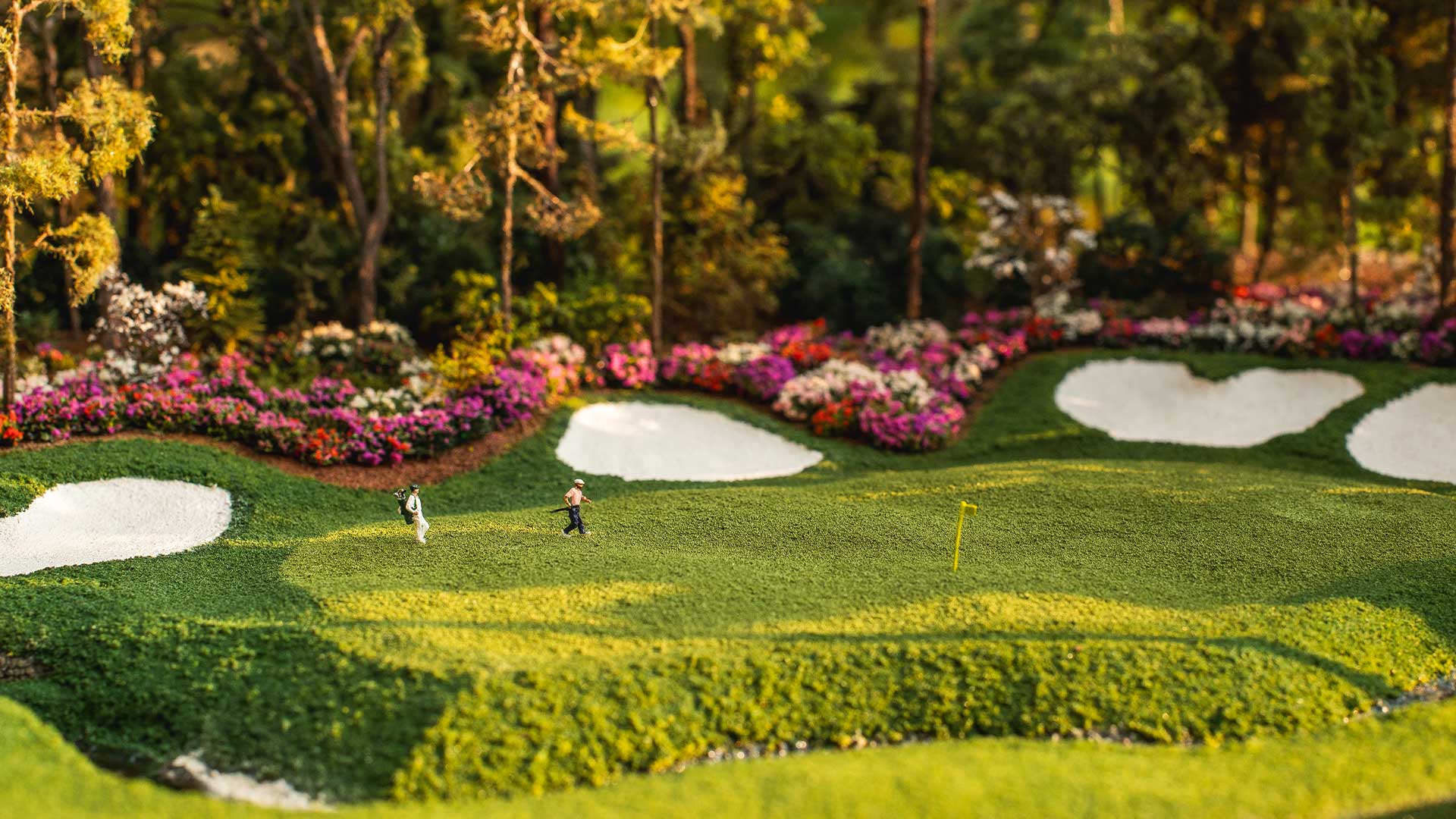 Detailed golfers on a green next to sand bunkers and captured in a handcrafted golf micro landscape