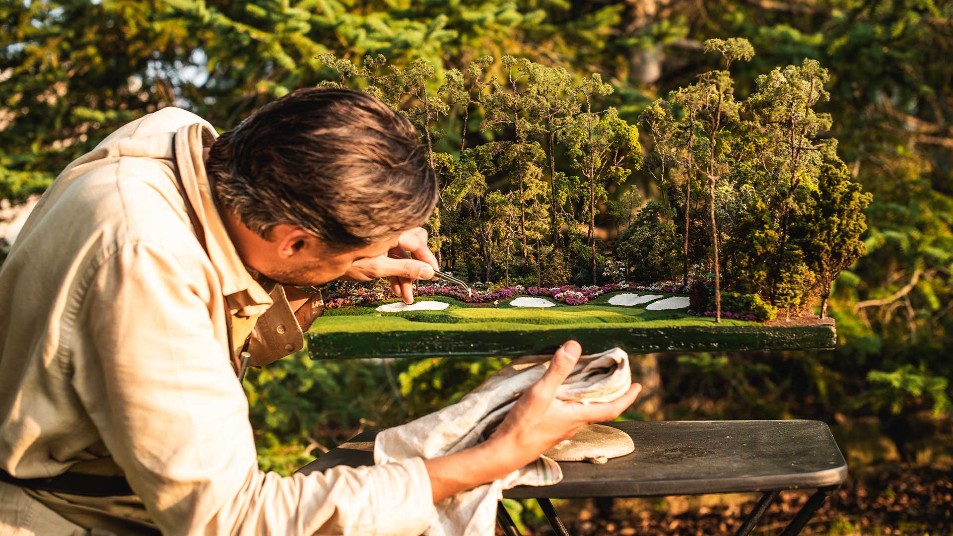 Micro Landscape artist outdoors putting final touches on the golf green