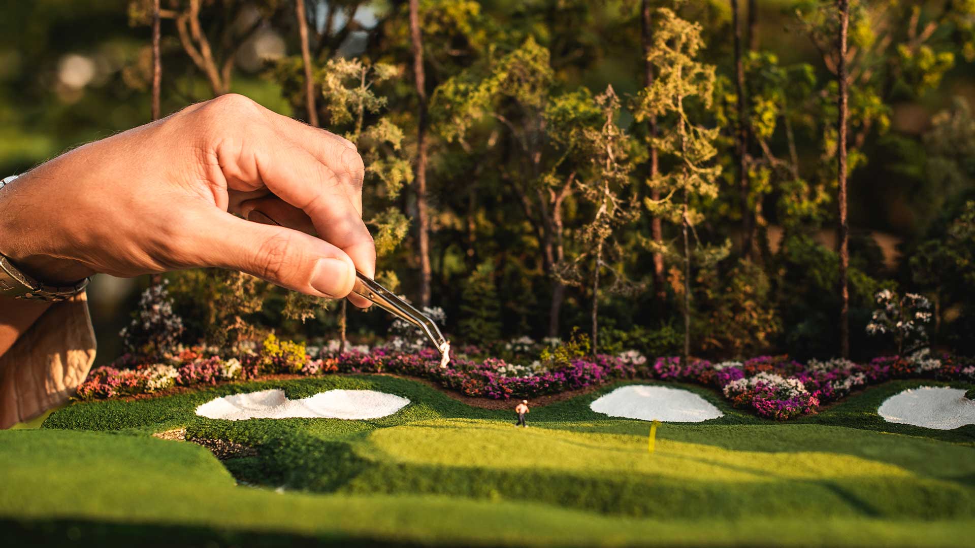 Micro Landscape artist placing the golfers on the green of the micro landscape