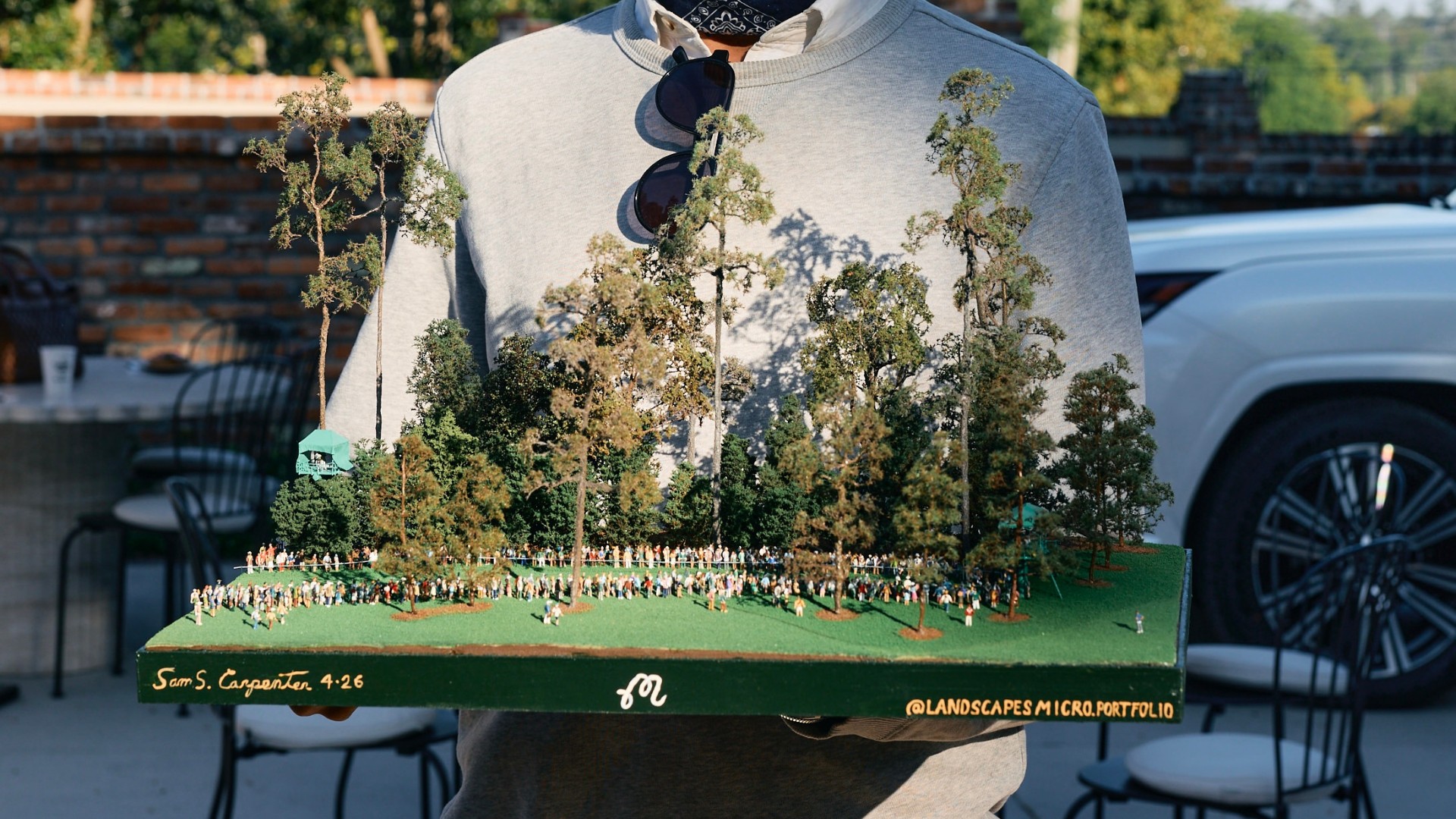 micro landscape architect holding golf course replica mobile
