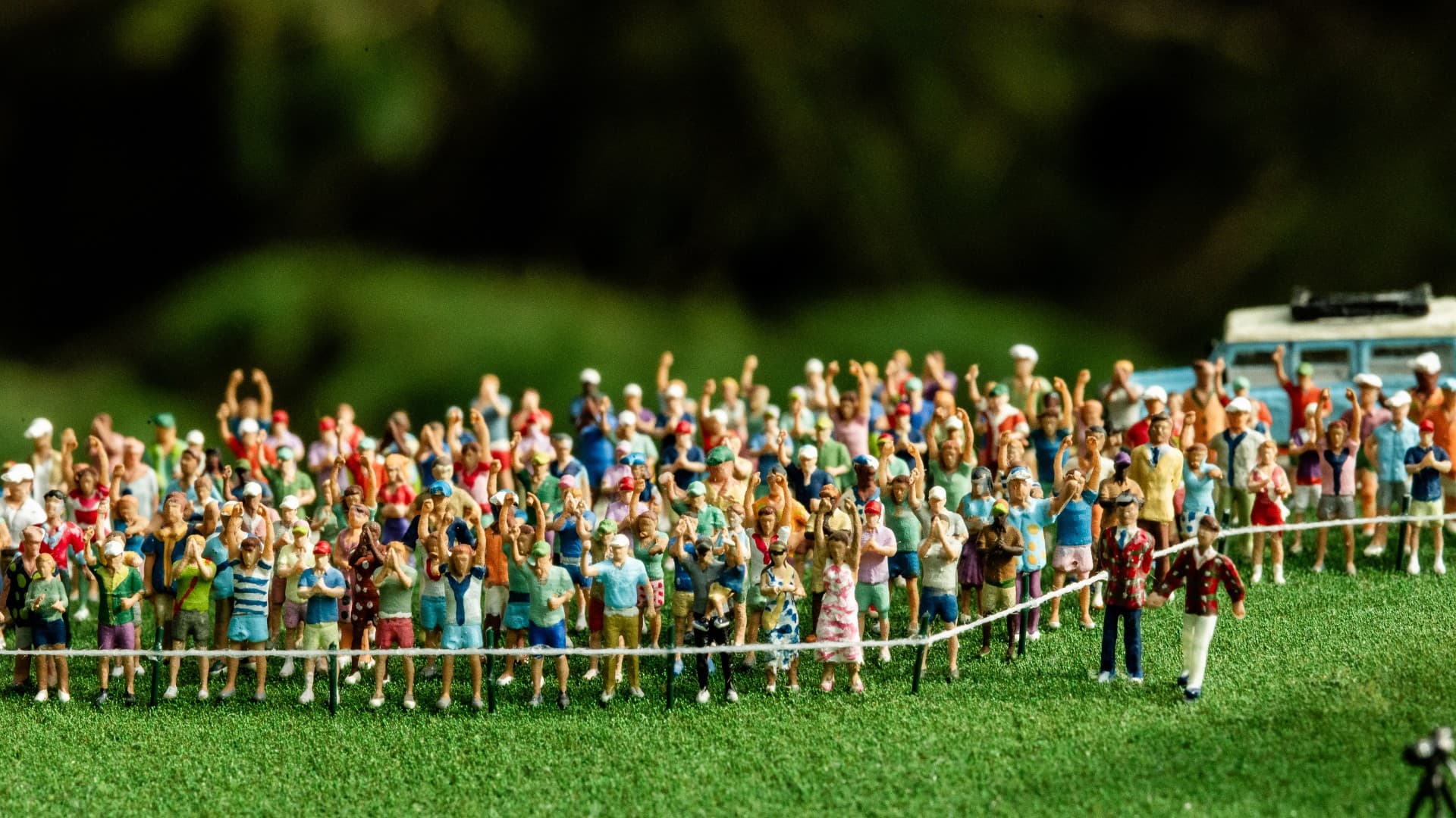 Hand-painted patrons surrounding the 18th green in a golf course replica