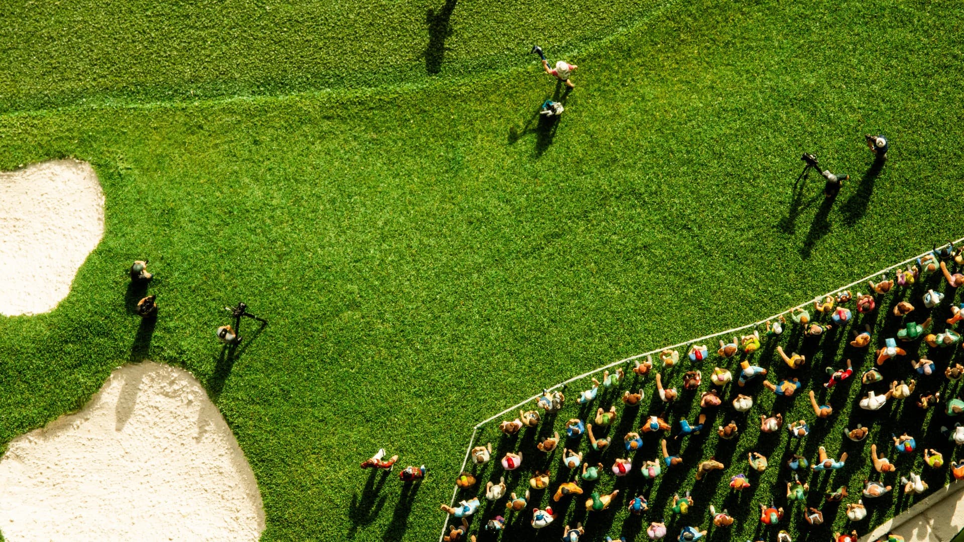 Handcrafted green and crowd around green within a custom golf course replica landscape
