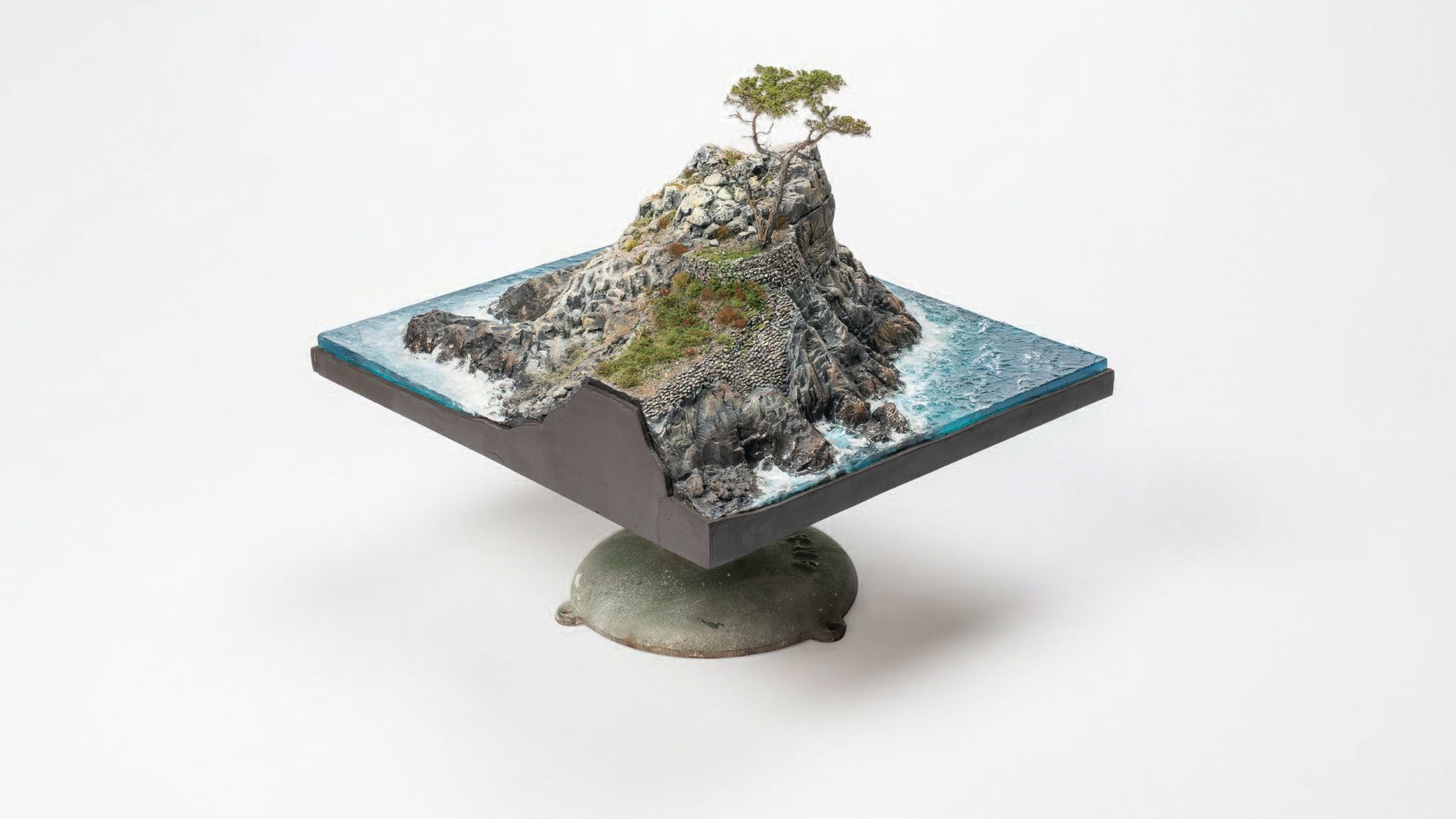 Miniature Monterey Cypress tree overlooking handcrafted coastal cliffs and ocean waters