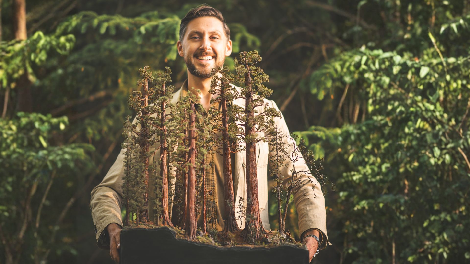 Micro landscape artist holding a handcrafted Redwood National Forest replica to demonstrate the scale and craftsmanship.